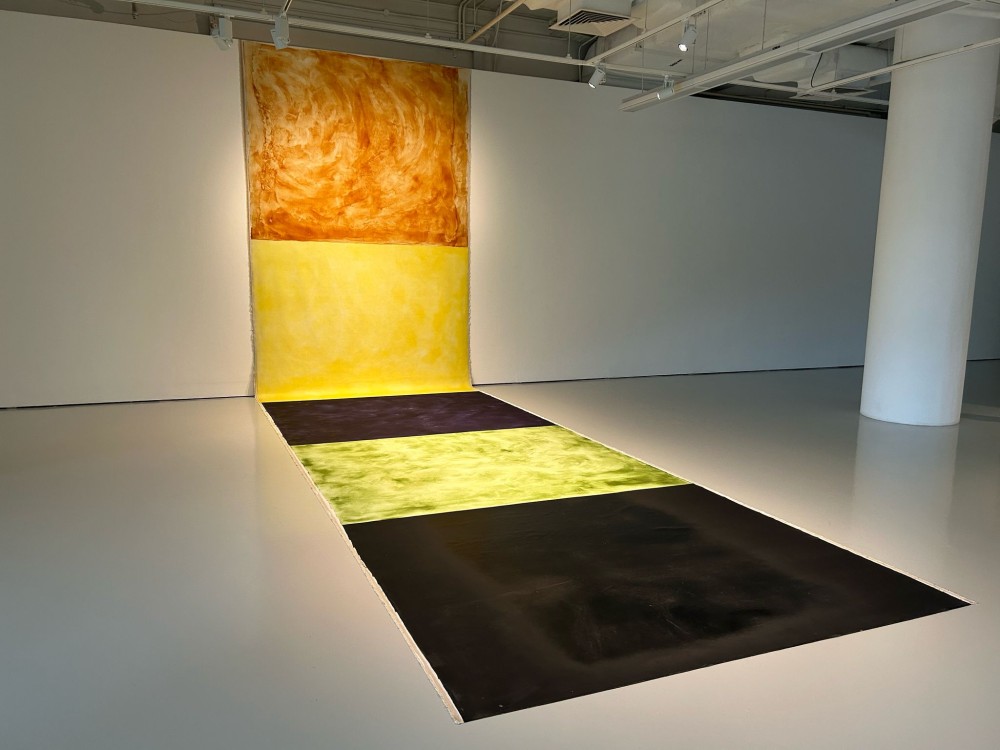 April 2025
Carbon, Linen Canvas, Pandan, Turmeric, Butterfly Pea Flower, Tomato
2.3m x 10m

In this exhibition, I explore the intricate and profound relationship between nature and the
everyday lives of Singaporeans through a series of paintings created with pigments I have
meticulously ground from natural materials. Each pigment carries the essence of
Singapore’s ecological and cultural identity, sourced from materials that are deeply
intertwined with the cultural history, environment, and way of life.
Singapore, a city-state often celebrated for its modernity, is also a place where nature and
urban life coexist in a delicate balance. From the lush greenery of its parks and reserves to
the vibrant hues of its native flora and fauna, the natural world is an integral part of
Singaporean identity. By using pigments derived from materials such as soil, leaves, flowers,
and other organic elements, I aim to reconnect viewers with the land and its stories, inviting
them to