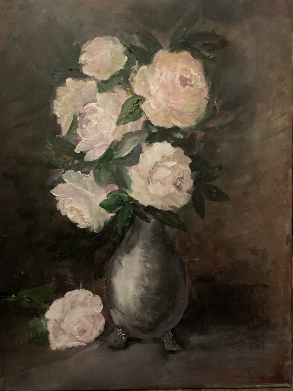 The painting depicts a delicate still life: at the center stands a dark, rounded vase, either clay or metal, holding lush white peonies tinged with pale pink. Their soft petals are rendered with broad, textured brushstrokes, creating a sense of both volume and fragility. The deep, muted brown background highlights the brightness of the blossoms, making them appear as if softly glowing against the shadows. In the foreground, at the base of the vase, rests a fallen flower — a symbol of fragility and the fleeting nature of beauty. The painting conveys a quiet atmosphere, filled with reflection and poetic melancholy.