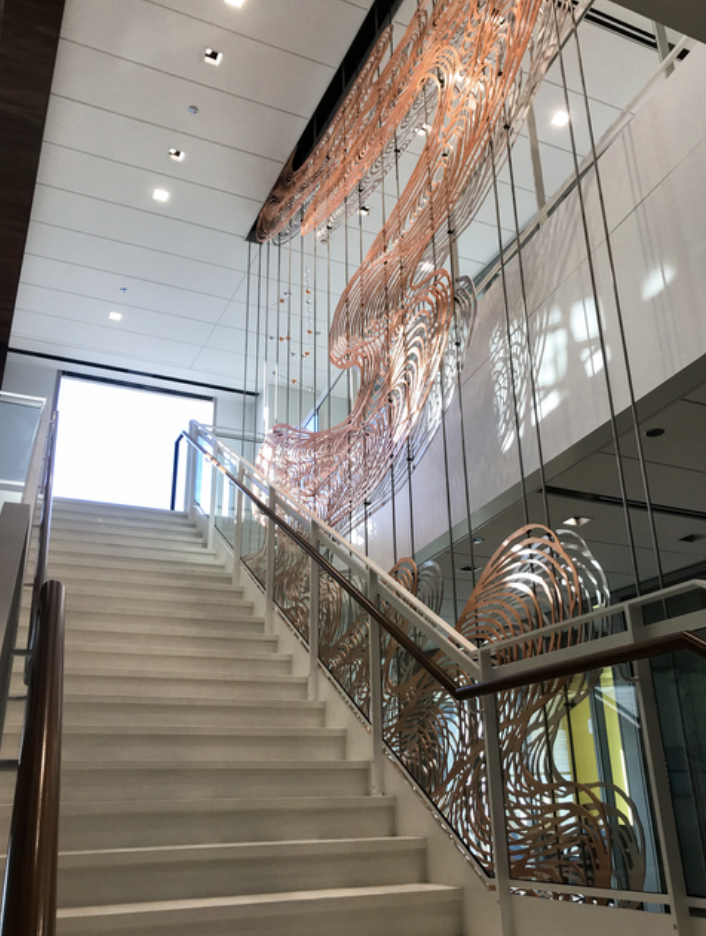 Two-story sculpture installed in corporate building. Water cut aluminum with bronze and silver gilding.
