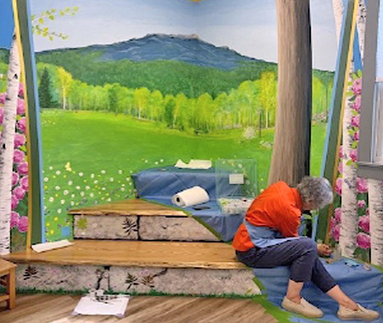 MEET UP AT THE STORYTELLER MOUNTAIN -- 
Created "For the children of Marlborough, in Loving Memory of Rufus S. Frost III"
Concept by Henry Barker, Library Director, and the Frost Family. A collaboration with artist carpenters Ted Mead and Chana Robbins of Marlborough and painter Holly Alderman of Jaffrey. 

FROST FREE LIBRARY OPEN HOURS: Tuesday 1-5:30, Wednesday 1-7, Thursday and Friday 10-5, Saturday 10-1. Closed Sunday and Monday. Info: frostfree.org.

SPECIAL THANKS GO TO: Kathleen Oliver, Co-Editor and Photographer of The MARLBOROUGH BULLETIN, not only for the artist-at-work photo above, but also for kind permission to reprint two articles, The Mural and The Muralist, reprints below and available in print at the Library.

About the painter

"...passionate and knowledgeable about the modern and post-modern in art, committed to conceptualize new forms that arise only from the present" -- Elatia Harris, in 3QD, interview with artist Holly Alderman

"Holly Alderman's work is a wonderful combination of modern and post-modern, as she creatively combines past and present, giving us multi-layered views of diverse worlds, that include the Renaissance, the 19th, 20th and 21st centuries. Her view if refreshing, poignant, and magical." -- Katherine Hoffman, ph.D., Chair of Fine Arts, St. Anselm College

"Holly Alderman's art combines serious purpose, wit and whimsy in an engaging alchemy. In the multi-layered images of the Cyber Heroes project for the National Academy she makes past and present speak to each other in a lively dialogue. Icons of New York's Gilded Age mingle with references to the city of today, while figures of dotted lights march in front, as if into the future. The effect is visually stunning and thought-provoking." -- Diana Wolfe Larkin, Ph.D., Art Historian

"It's fantastic what you did with the light man, the bulbs, the reflection, and the firemen, and everything... with the silhouette of the light man walking behind. I love him. It looks great." Tom Petrovich, Manager, Bergdorf Goodman Men's, Fifth Avenue NY NY