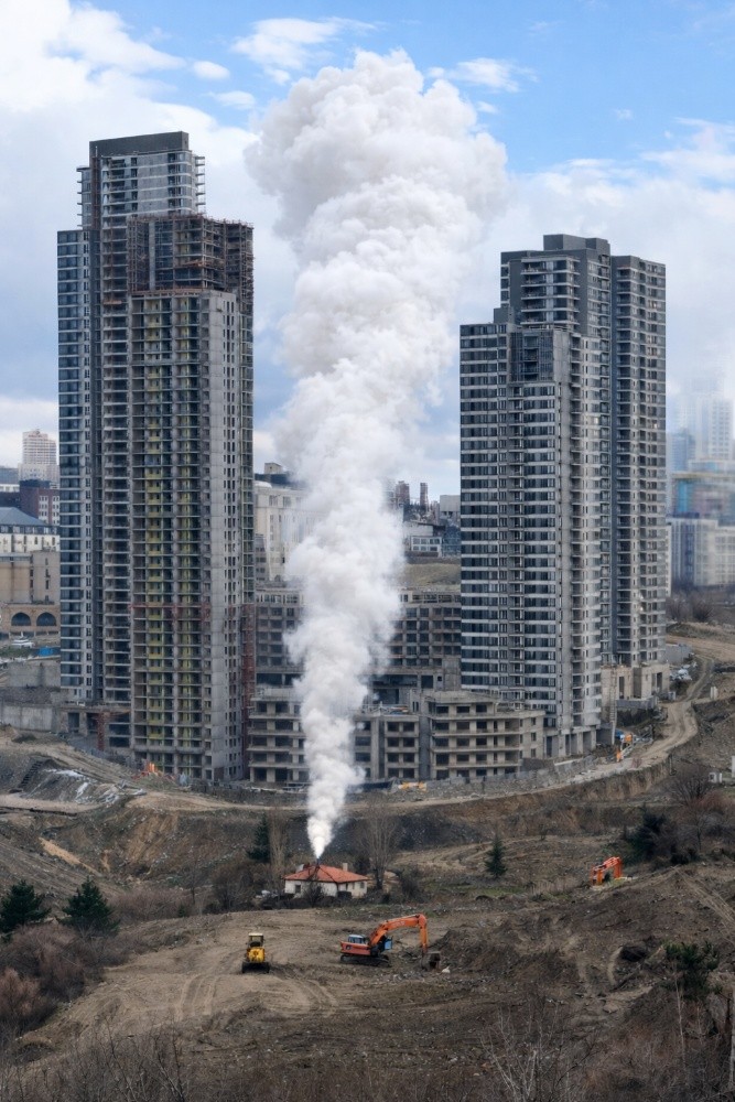 While walking in the rain along a fixed route, I encountered a small yet defiant informal dwelling surrounded by excavators. It stood as if resisting erasure. Recalling Murat Germen’s Fikirtepe “Tower of Babel” (2014), I imagined smoke rising from its chimney — a sign that life still persisted. I later inserted this imagined smoke into the photograph, transforming a gesture of resistance into a visual element.

The work questions why “height” is glorified in contemporary urban culture. Skyscrapers appear less as necessity and more as symbols of dominance — assertions of visibility and power.

The smoke rising from the gecekondu becomes a fragile yet clear counter-gesture: upward, uncontrolled, and modest. It suggests that space is not defined solely by concrete and elevation, and that even the tallest structures may suffocate. Breathing Space reflects on resistance as a minimal yet forceful interruption within imposed narratives of progress.